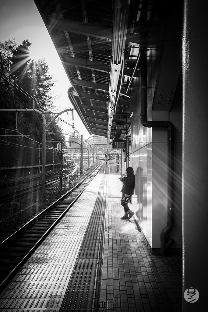 Jeune fille qui attend le train à Tokyo, Japon, photographie de Romain Guélat
